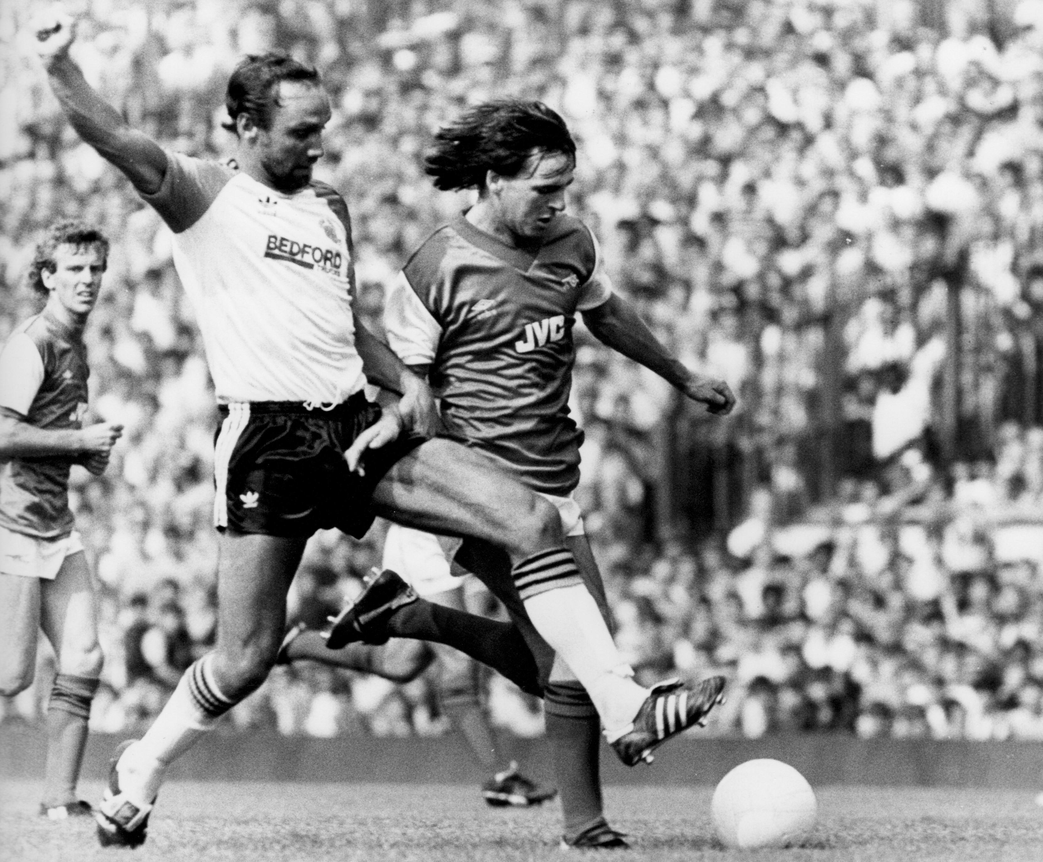 Brian Horton looks to knock the ball away from Charlie Nicholas